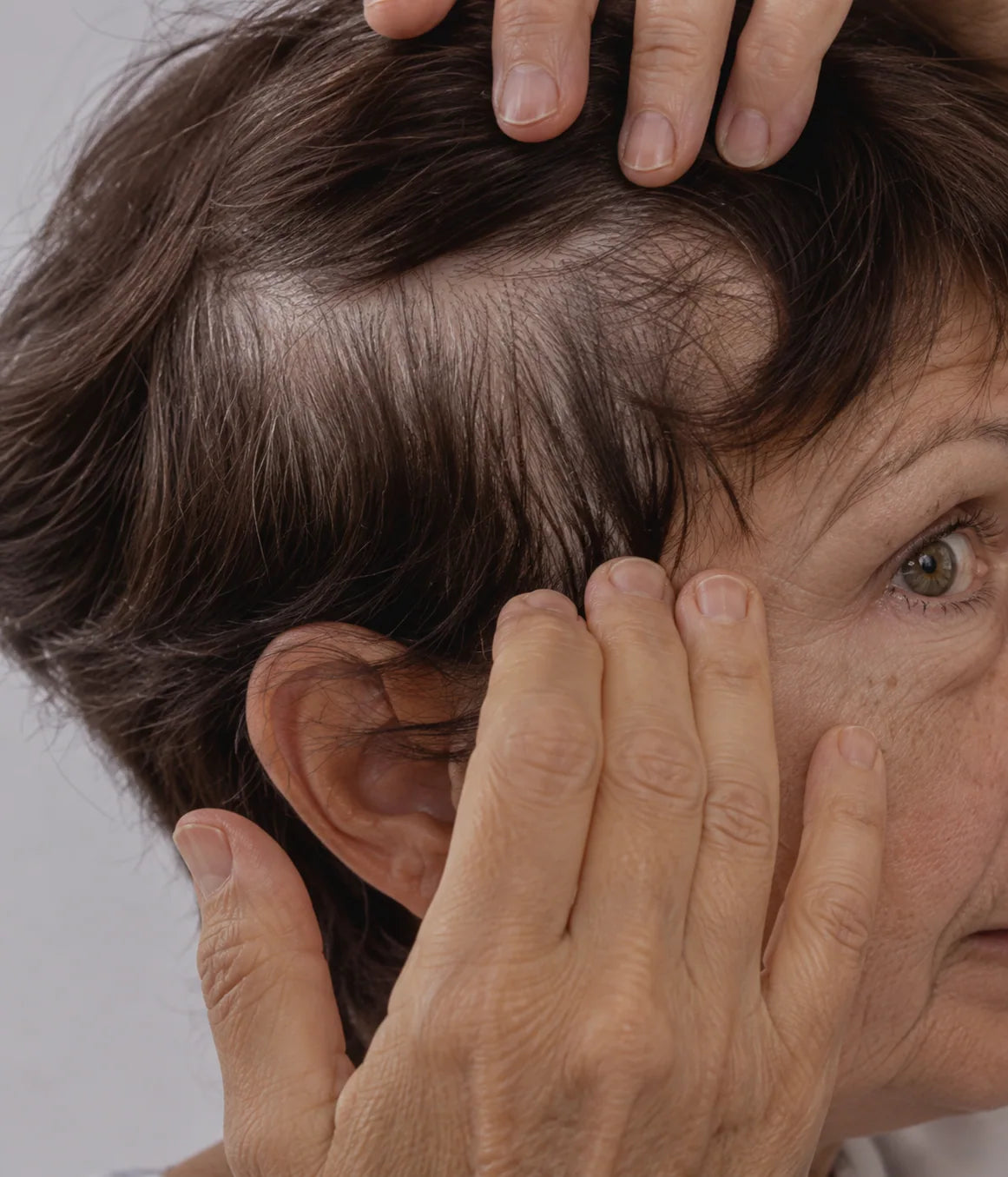 Hair-care scene with a woman gently parting her brown hair